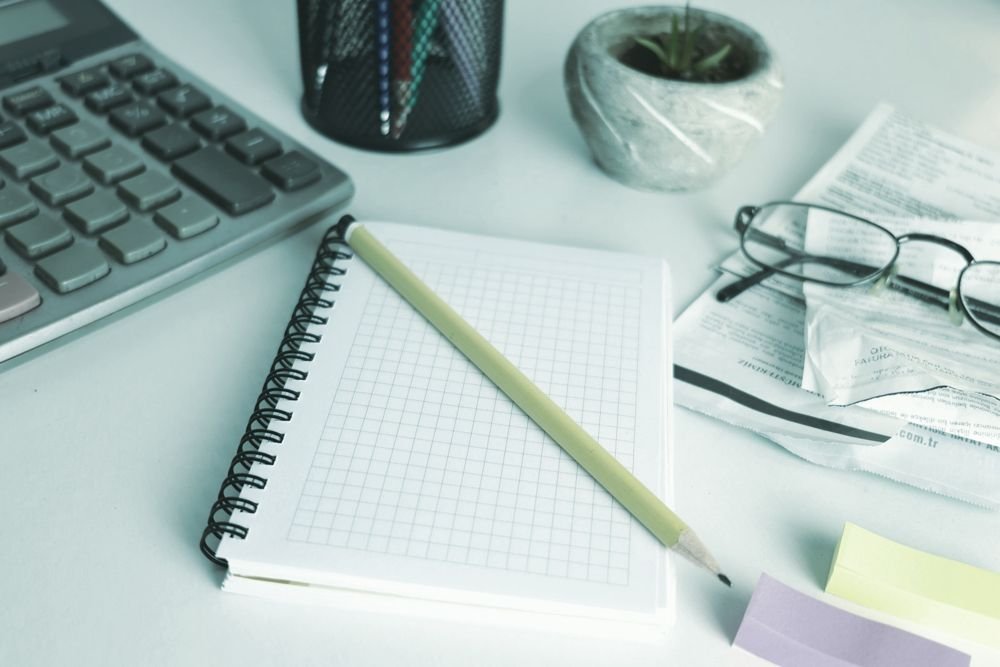 Mesa de trabajo con calculadora, libreta y documentos